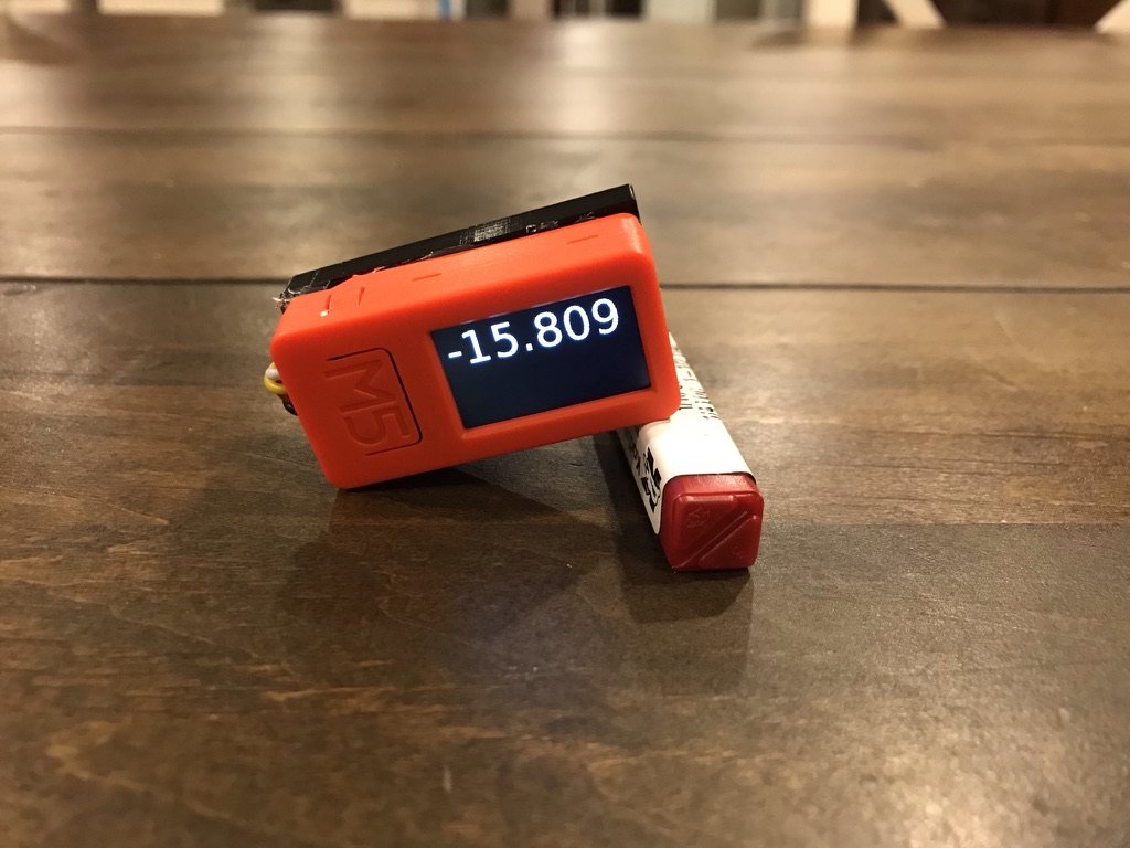 The 2021 prototype: an M5StickC in its orange case with an external accelerometer board wired on top, screen reading minus 15.809 degrees.